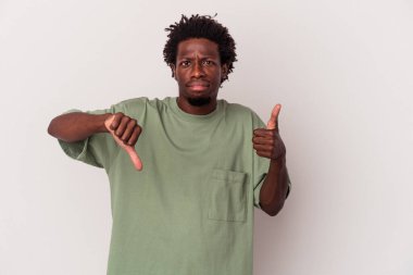 Beyaz arka planda izole edilmiş genç Afro-Amerikalı adam baş parmağını kaldırıyor ve baş parmağını aşağı gösteriyor, zor seçim konsepti