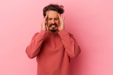 Pembe arka planda izole edilmiş genç beyaz adam tapınaklara dokunuyor ve baş ağrısı çekiyor..