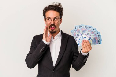 Beyaz arka planda izole edilmiş banknotları elinde tutan genç beyaz adam gizli bir fren haberinin olduğunu söylüyor.