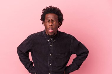 Genç Afrikalı Amerikalı bir adam pembe arka planda izole edilmiş komik ve dost canlısı bir dil kullanıyor..