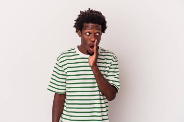 Beyaz arka planda izole edilmiş genç Afro-Amerikan bir adam gizli bir sıcak fren haberi veriyor ve kenara bakıyor.