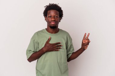 Genç Afrikalı Amerikalı adam beyaz arka planda izole edilmiş bir şekilde yemin ediyor, elini göğsüne koyuyor..