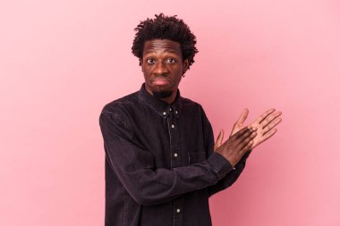 Genç Afro-Amerikan erkeği pembe arka planda izole edilmiş enerjik ve rahat hissediyor, kendinden emin ellerini ovuşturuyor..