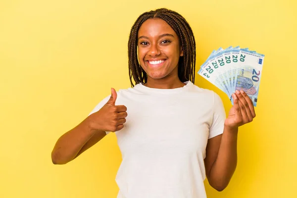 Mladá Africká Američanka Drží Bankovky Izolované Žlutém Pozadí Úsměvem Zvednutím — Stock fotografie