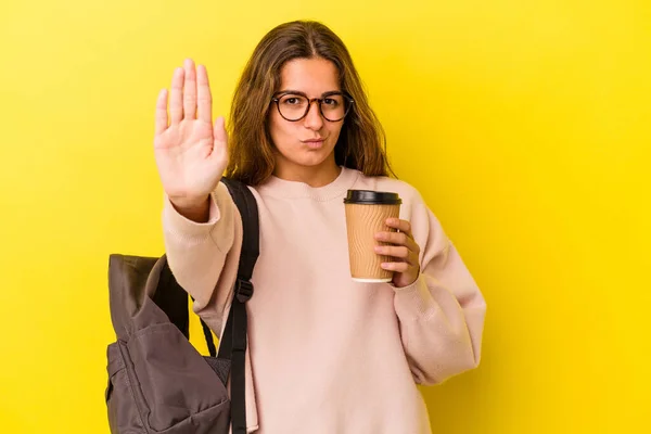 Jovem Estudante Caucasiano Segurando Café Isolado Fundo Amarelo Com Mão — Fotografia de Stock