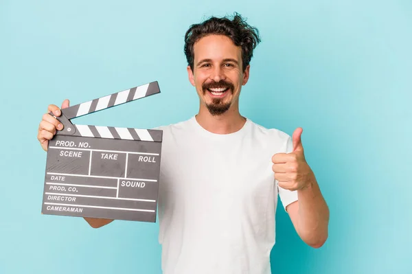 Young Caucasian Man Holding Clapperboard Isolated Blue Background Smiling Raising — Stock Photo, Image