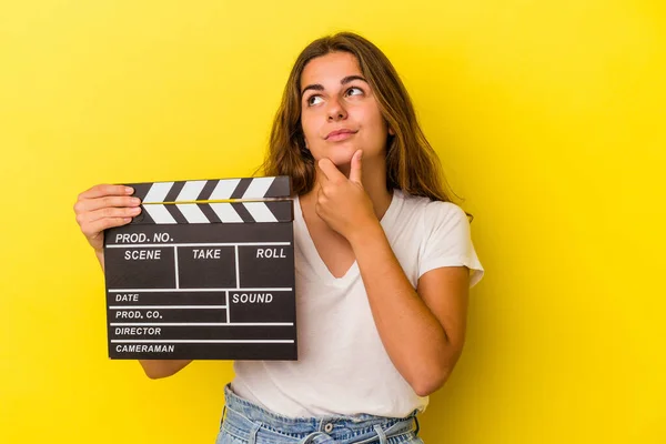 Mulher Caucasiana Jovem Segurando Clapperboard Isolado Fundo Amarelo Olhando Para — Fotografia de Stock