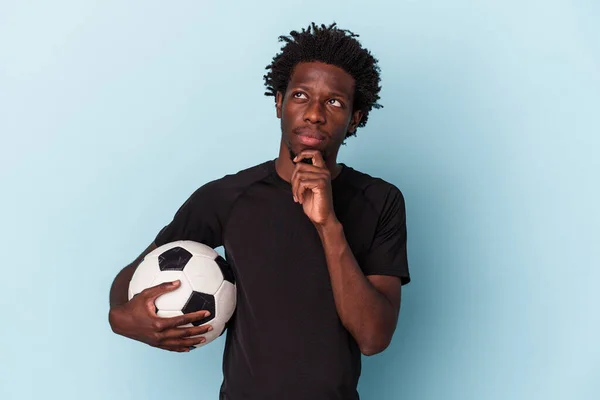 Joven Afroamericano Jugando Fútbol Aislado Sobre Fondo Azul Mirando Hacia —  Fotos de Stock