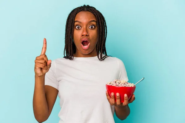 一个年轻的非裔美国女人拿着一碗谷物 被蓝色背景隔离 有一些伟大的想法 创意的概念 — 图库照片