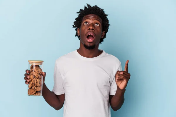 Mladý Africký Američan Drží Čokoládové Lupínky Cookies Izolované Modrém Pozadí — Stock fotografie