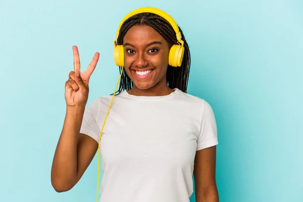 Jovem Afro Americana Ouvindo Música Isolada Fundo Azul Mostrando Número — Fotografia de Stock