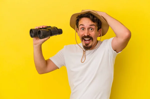 Young Caucasian Man Holding Binoculars Isolated Yellow Background — Stock Photo, Image