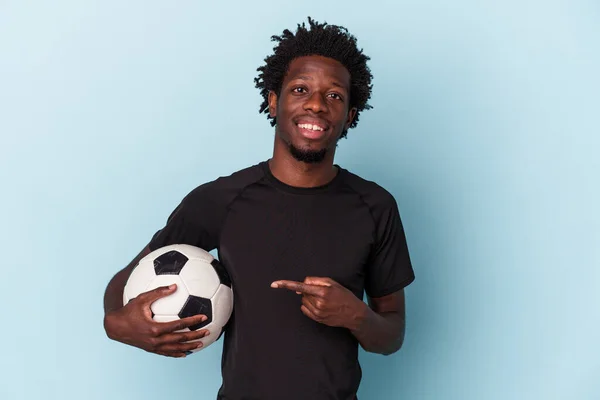 Joven Afroamericano Jugando Fútbol Aislado Sobre Fondo Azul Sonriendo Señalando —  Fotos de Stock