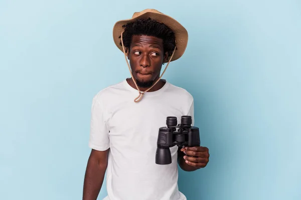 Young African American Man Holding Binoculars Isolated Blue Background Confused — ストック写真