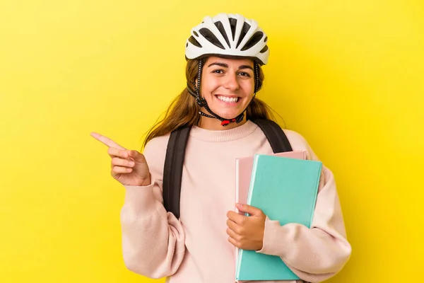 배경에 고립된 자전거 헬멧을 코카서스 여학생이 웃으며 가리켜서 공간에 무언가를보여 — 스톡 사진
