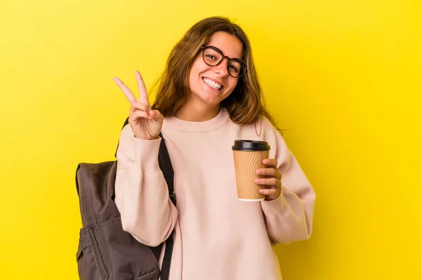 Joven Estudiante Caucásica Sosteniendo Café Aislado Sobre Fondo Amarillo Mostrando —  Fotos de Stock