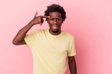 Pembe arka planda izole edilmiş genç Afro-Amerikalı adam işaret parmağıyla hayal kırıklığı jesti yapıyor..