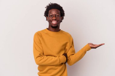 Beyaz arka planda izole edilmiş genç Afro-Amerikalı bir adam bir avuç içinde fotokopi alanı gösteriyor ve belinde başka bir el tutuyor..