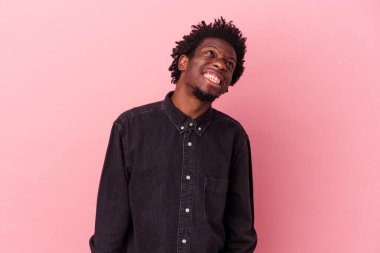 Genç Afrikalı Amerikalı adam pembe arka planda izole edilmiş dans ediyor ve eğleniyor..