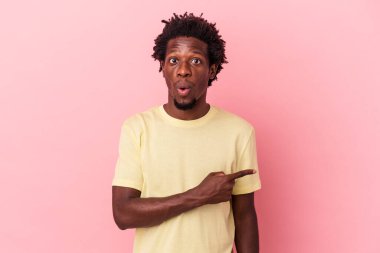 Pembe arka planda izole edilmiş genç Afro-Amerikan bir adam.