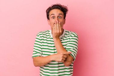 Pembe arka planda izole edilmiş genç beyaz adam yan tarafı gösteriyor.