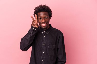 Genç Afrikalı Amerikalı adam pembe arka planda izole edilmiş. İki numarayı parmaklarıyla gösteriyor..