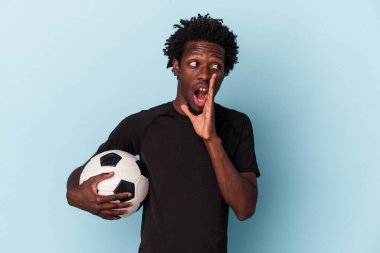 Mavi arka planda izole bir şekilde futbol oynayan Afro-Amerikan genç adam gizli bir sıcak fren haberi veriyor ve kenara bakıyor.