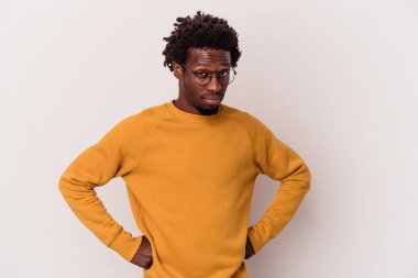 Beyaz arka planda izole edilmiş, hoşnutsuzca kaşlarını çatmış, kollarını kavuşturmuş genç Afrikalı Amerikalı bir adam..