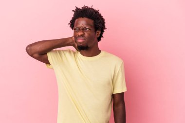 Genç Afrikalı Amerikalı bir adam pembe arka planda izole edilmiş kafasının arkasına dokunuyor, düşünüyor ve bir seçim yapıyor..