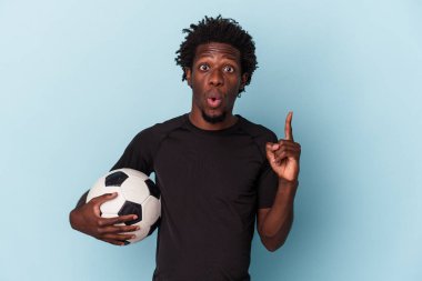 Amerikan futbolu oynayan genç Afro-Amerikan bir adam mavi arka planda izole edilmiş, harika bir fikri var, yaratıcılık kavramı..