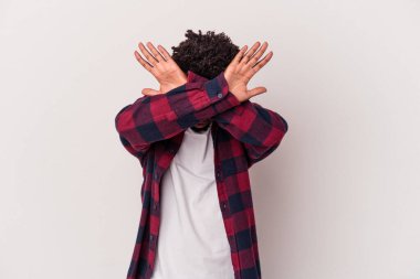 Genç Afrikalı Amerikalı adam beyaz arka planda izole edilmiş iki kolu çapraz tutuyor, inkar kavramı.