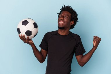 Genç Afro-Amerikan futbol oynayan adam mavi arka planda izole edilmiş.