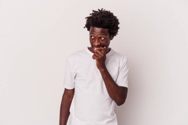 Beyaz arka planda izole edilmiş genç Afrikalı Amerikalı bir şey hakkında rahatça düşünüyor ve bir fotokopi odasına bakıyor..