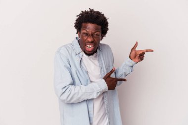 Beyaz arka planda izole edilmiş genç bir Afrikalı Amerikalı işaret parmağıyla fotokopi alanını işaret ederek heyecan ve arzusunu ifade ediyor..