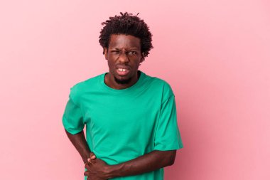Genç Afrikalı Amerikalı bir adam pembe arka planda izole edilmiş karaciğer ağrısı, karın ağrısı var..