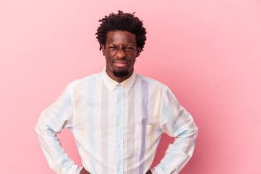 Genç Afrikalı Amerikalı bir adam pembe arka planda izole edilmiş üzgün, ciddi yüzlü, mutsuz ve hoşnutsuz..