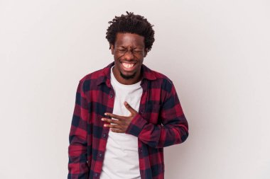 Beyaz arka planda izole edilmiş genç Afrikalı Amerikalı adam elini göğsüne koyduğunda kahkahalar atıyor..