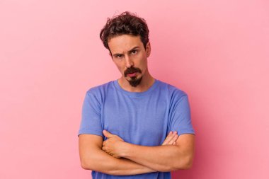 Pembe arka planda izole edilmiş genç beyaz adam sıkılmış, yorgun ve dinlenmeye ihtiyacı var..