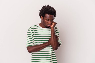 Beyaz arka planda izole edilmiş genç Afrikalı Amerikalı üzgün ve dalgın bir şekilde fotokopi odasına bakıyor..