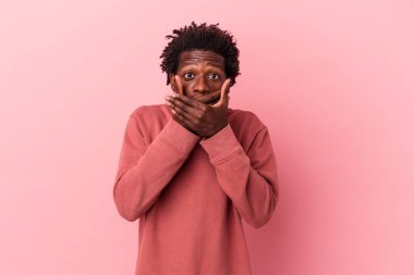 Genç Afrikalı Amerikalı bir adam pembe arka planda izole edilmiş ağzı kapalı ve endişeli görünüyor..