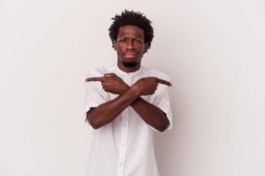 Beyaz arka plan noktalarında izole edilmiş genç Afrikalı Amerikalı iki seçenek arasında seçim yapmaya çalışıyor..