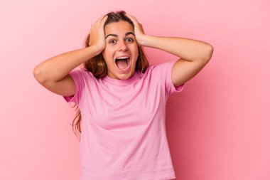 Pembe arka planda izole edilmiş genç beyaz kadın çığlık atıyor, çok heyecanlı, tutkulu, bir şeyden memnun..