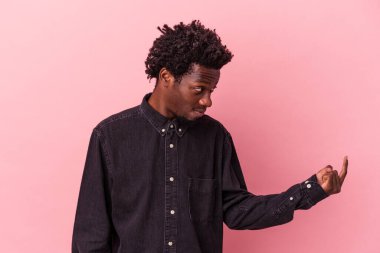 Pembe arka planda izole edilmiş genç Afro-Amerikan erkeği sanki seni davet ediyormuş gibi parmağıyla işaret ediyor..