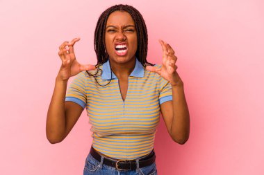 Genç Afrikalı Amerikalı kadın pembe arka planda izole edilmiş öfkeyle bağırıyor..