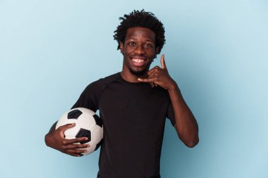 Amerikan futbolu oynayan genç Afro-Amerikan bir adam mavi arka planda izole edilmiş, parmaklarıyla bir cep telefonu hareketi gösteriyor..