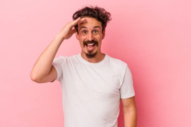 Pembe arka planda izole edilmiş genç beyaz adam yüksek sesle bağırıyor, gözleri açık ve elleri gergin tutuyor..