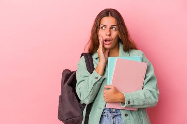 Elinde pembe arka planda izole edilmiş kitaplar tutan beyaz bir kadın gizli bir fren haberinin olduğunu ve yan gözle baktığını söylüyor.