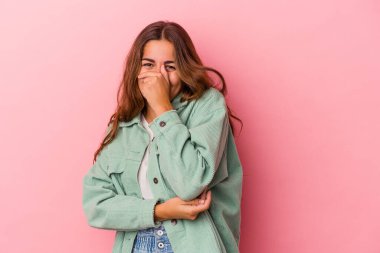 Pembe arka planda soyutlanmış genç beyaz kadın gülüyor, kaygısız, doğal duygu..