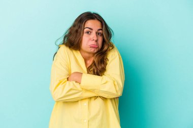 Mavi arka planda soyutlanmış beyaz bir kadın omuzlarını silker ve gözleri açık kalır..