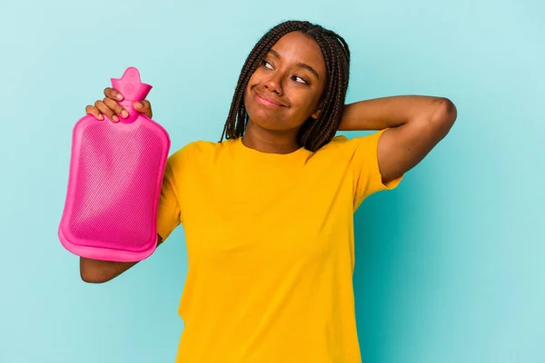 Young African American Woman Holding Hot Bag Water Isolated Blue — Stockfoto